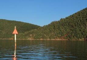 A red triangle channel marker near the base of Smith Mountain.